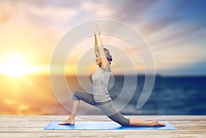 Happy woman making yoga in low lunge on mat