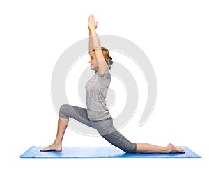 Happy woman making yoga in low lunge on mat