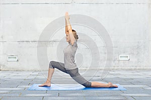 Happy woman making yoga in low lunge on mat