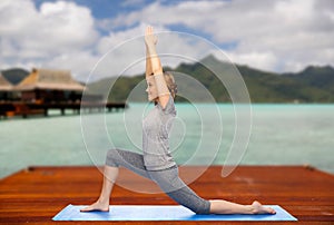 Happy woman making yoga in low lunge outdoors