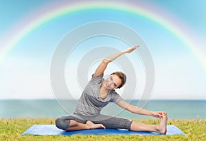 Happy woman making yoga and stretching on mat