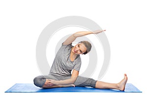 Happy woman making yoga and stretching on mat