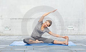 Happy woman making yoga and stretching on mat