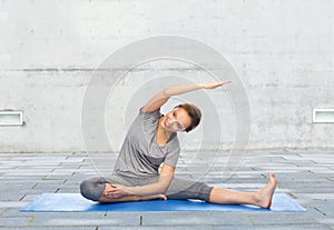 Happy woman making yoga and stretching on mat