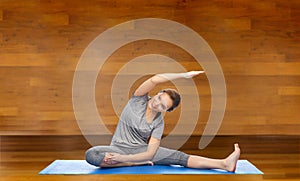 Happy woman making yoga and stretching on mat