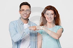 Happy woman and man giving fist bump looking at camera