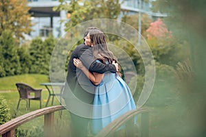 Happy woman and man standing hugging outdoors