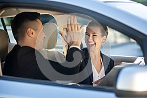 Happy woman and man touching welcoming in car