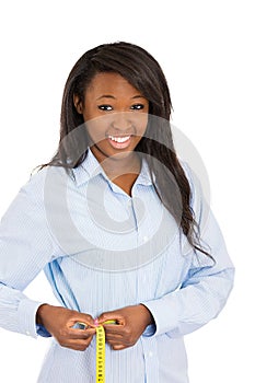 Happy woman measuring her waist line with tape