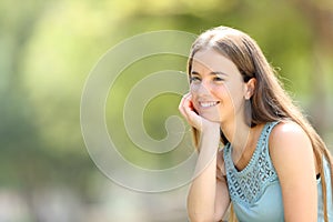 Happy woman meditating looking away in a park