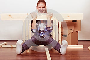 Happy woman moving in assembly furniture at home.