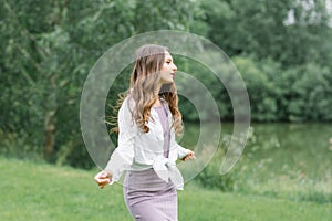 A happy woman in nature. Portrait of a beautiful girl in close-up on the background of the lake. Young smiling woman outdoor