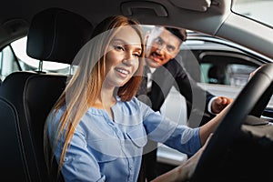 Happy woman new car owner sitting in driver seat