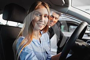 Happy woman new car owner sitting in driver seat