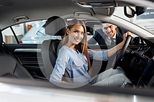 Happy woman new car owner sitting in driver seat