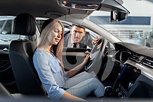 Happy woman new car owner sitting in driver seat