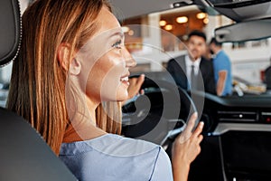 Happy woman new car owner sitting in driver seat