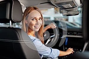 Happy woman new car owner sitting in driver seat