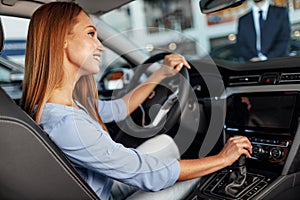 Happy woman new car owner sitting in driver seat