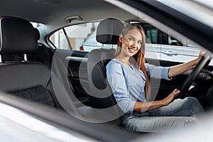 Happy woman new car owner sitting in driver seat