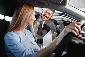 Happy woman new car owner sitting in driver seat