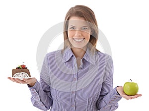 Happy woman offering cake and apple