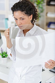 happy woman at office drinking hot coffee