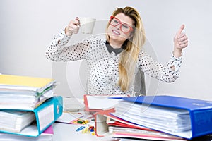 Happy woman at office drinking hot coffee