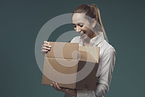 Happy woman opening a delivery box