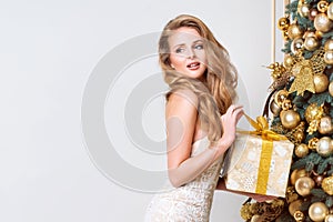 Happy woman opening gift box. Luxury blonde with Christmas gift. Merry Christmas and Happy New Year celebration theme. Young