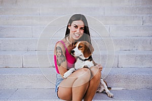 Happy woman outdoors with her beagle dog. Family and lifestyle concept