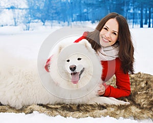 Happy woman owner having fun with white Samoyed dog outdoors