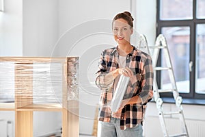 happy woman packing shelf and moving to new home