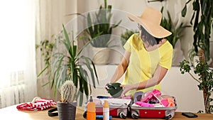 Happy woman packing suitcase, put snorkeling, diving mask, getting ready for summer vacation