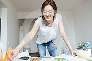 Happy woman painter working in art studio