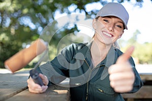 happy woman painting picnic bench