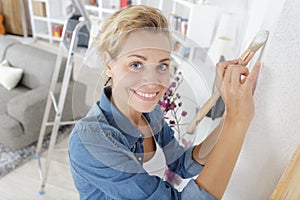 happy woman painting wall