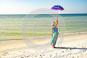 Happy woman in a pareo with umbrella i