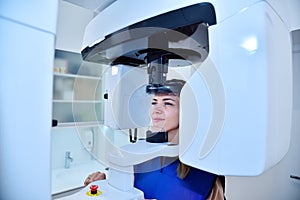 Happy woman patient make a panoramic computer tomograph in clinic