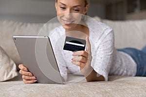 Happy woman pay online on tablet with credit card