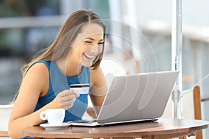 Happy woman paying on line with a credit card