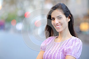 Happy woman with perfect smile in the street looks at camera