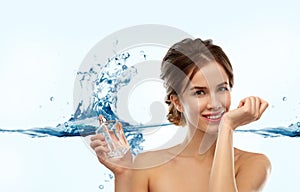 Happy woman with perfume over water splash