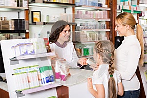 Happy woman pharmacist helping customers