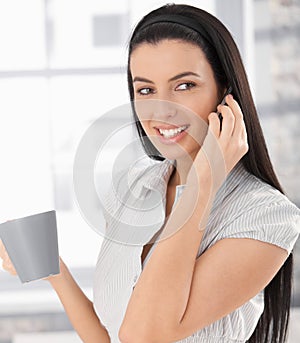 Happy woman on phone call with coffee