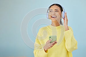 Happy woman with phone, headphones and banner mockup in studio on social media, mobile app and streaming radio. Smile