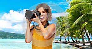 Happy woman photographer with camera on beach