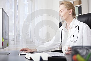 Happy Woman Physician Surfing Internet on Computer