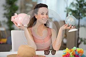 happy woman with piggy bank and globe concept