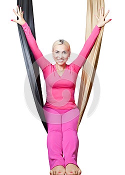 Happy woman in pink sports suit sitting in hanging the hammock